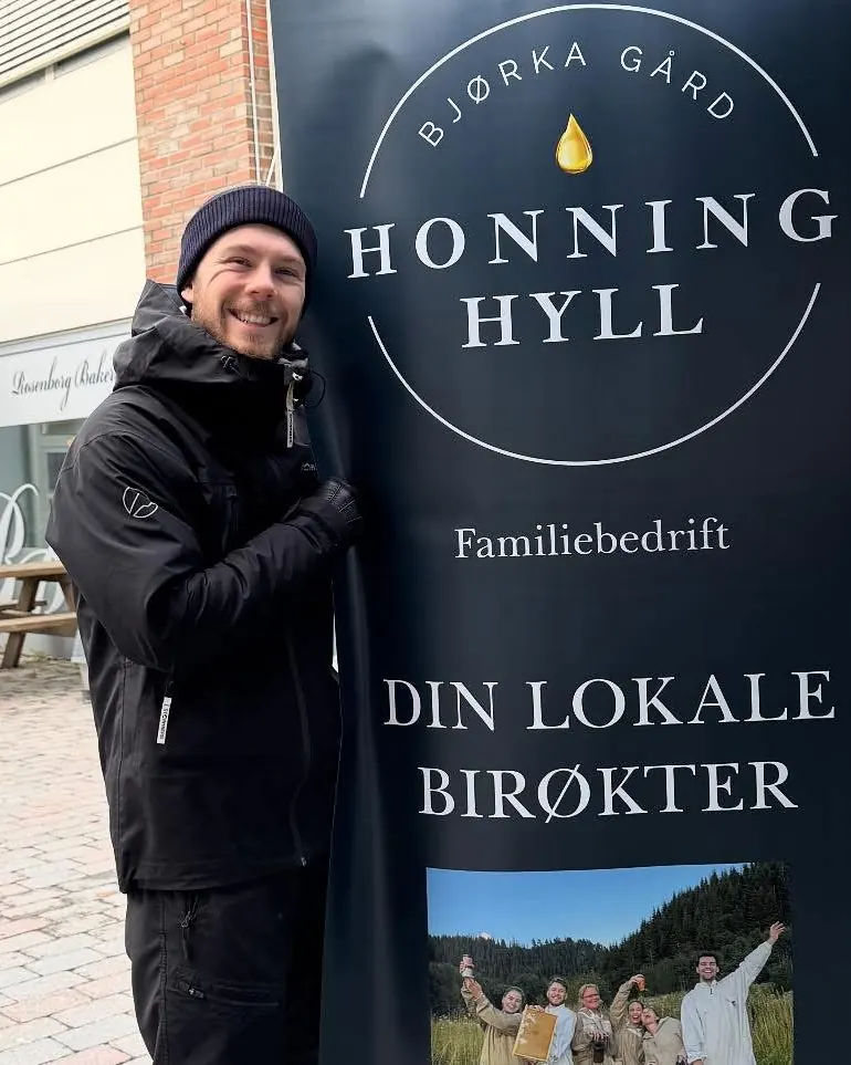 Birøkter ved Honning Hyll-skiltet utenfor butikken